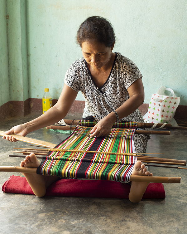 A weaver using a body-tensioned loom